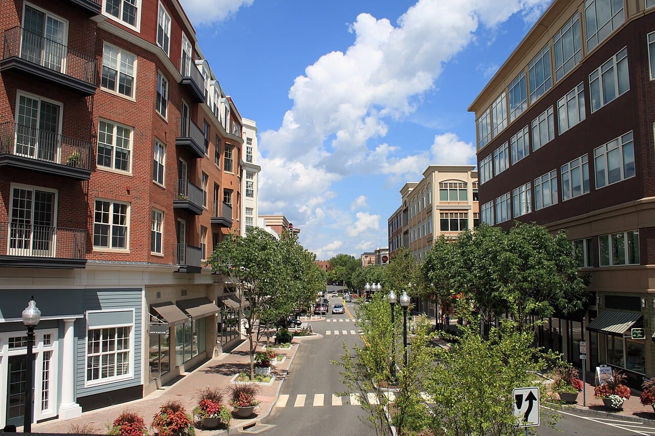 Looking down a tree-lined street of brick shops and residences in West Hartford Center's Blue Back Square